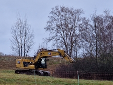 Ein Bagger entfernt Schlehengebüsche auf den Projektflächen.